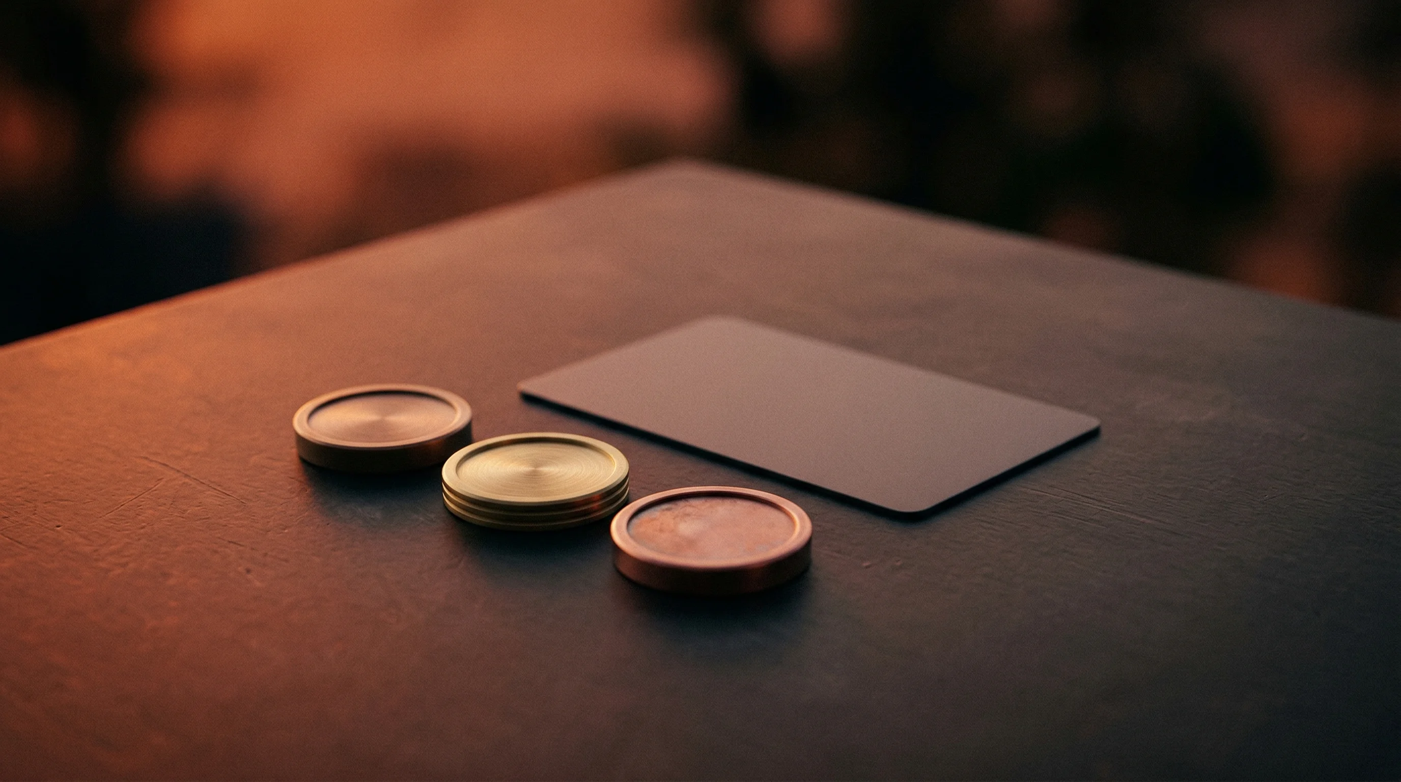 Digital illustration for article section "Free Tier Economics" in "YC-Backed Didit Launches Face Scan Identity Platform Amid Fraud Surge" - A clean, minimalist composition featuring a neat arrangement of sleek, modern metallic tokens restin...