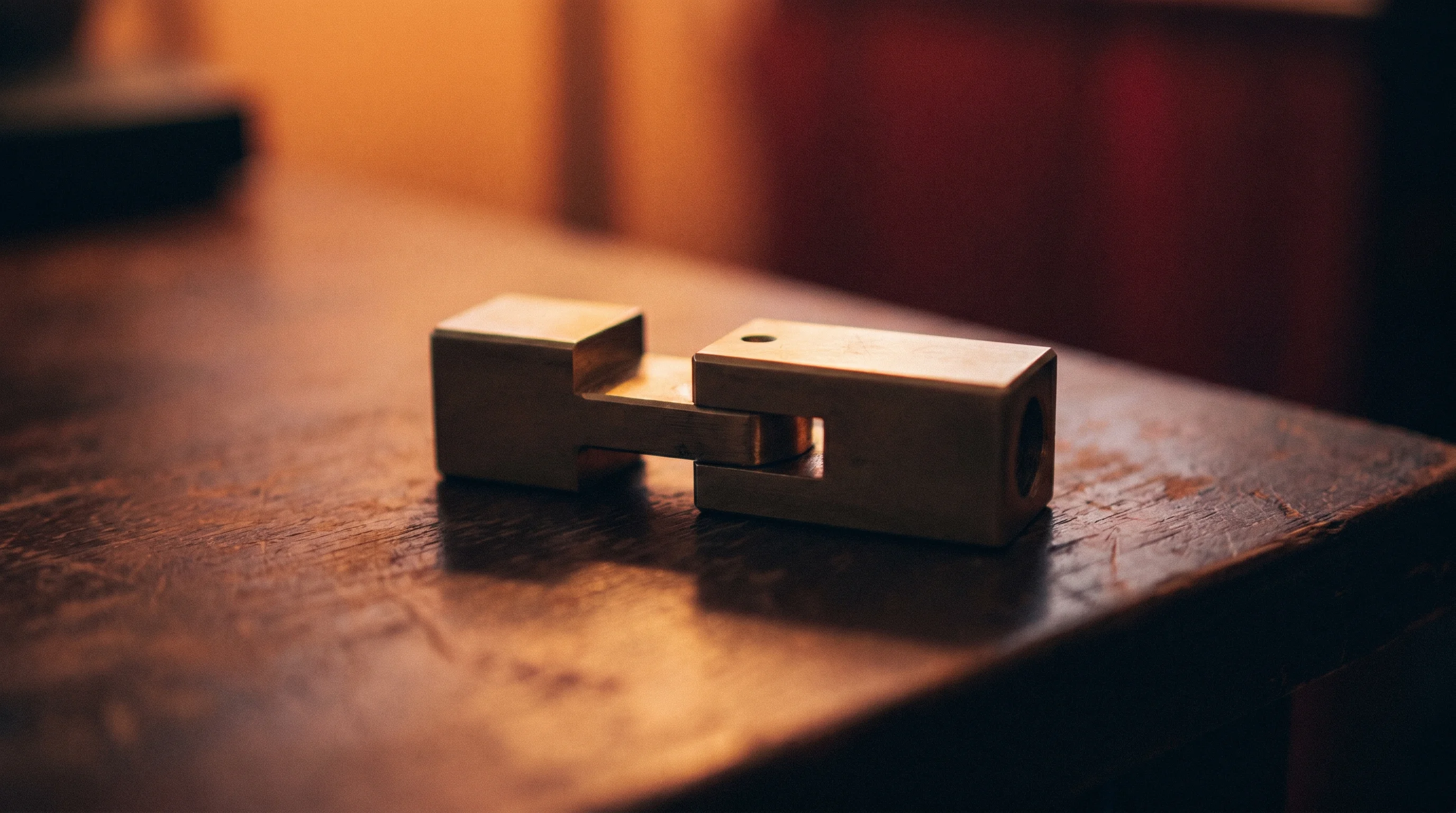 Digital illustration for article section "The Quieter War Over Standards" in "The AI Orchestration Wars: Open Source Upstarts Challenge Tech Giants" - A minimalist, conceptual close-up of a beautifully crafted, solid brass interlocking mechanism perfe...